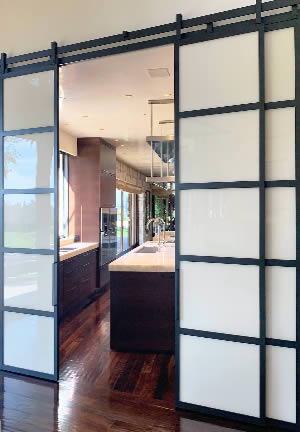 Large Metal and Glass Barn Doors Between Kitchen and Dining Room